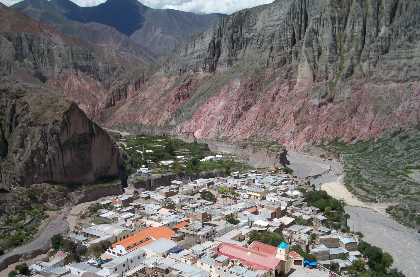 "Esta imagen captura la cautivante belleza del noroeste argentino (NOA), donde los colores vibrantes de la naturaleza pintan un cuadro impresionante. Las montañas de la Quebrada de Humahuaca se presentan majestuosas, mostrando capas geológicas que cuentan historias milenarias. Pueblos pintorescos se asientan en los valles, rodeados de un paisaje donde el verde intenso de los cerros se encuentra con el azul profundo del cielo. Es una región que respira historia y cultura, donde las tradiciones locales y la naturaleza se entrelazan en una danza armoniosa. Esta imagen es un vistazo a la riqueza del NOA, una invitación a explorar sus maravillas naturales y culturales."