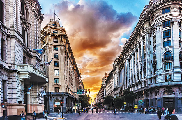 "La imagen captura la energía y la diversidad de Buenos Aires, la 'Paris de América'. Sus calles están impregnadas de historia y cultura, reflejadas en la arquitectura ecléctica que combina estilos europeos y latinoamericanos. Las avenidas amplias y arboladas dan paso a plazas animadas donde la gente se reúne para conversar y disfrutar de la vida. El tango flota en el aire, llevando consigo el espíritu apasionado de la ciudad. Es un lugar donde la gastronomía es un arte, desde los deliciosos asados hasta las empanadas. Esta imagen es una invitación a sumergirse en el alma de Buenos Aires, a descubrir su encanto cultural, su rica historia y su pasión por la vida."